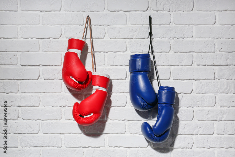 Fototapeta Boxing gloves hanging on brick wall