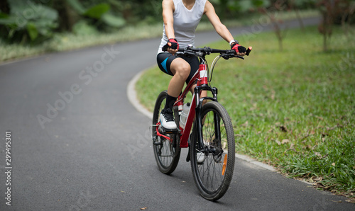 Woman  riding bike in park © lzf