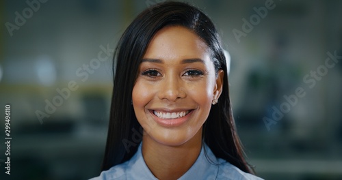 Fényképezés Portrait of an young successful dark skin businesswoman is smiling satisfied with her work in camera in an office