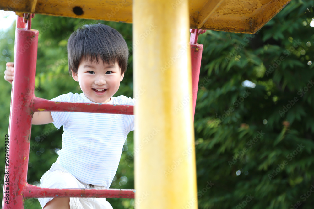 Fototapeta premium すべり台で遊ぶ男の子
