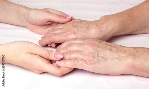 A young woman holding an older woman's hands