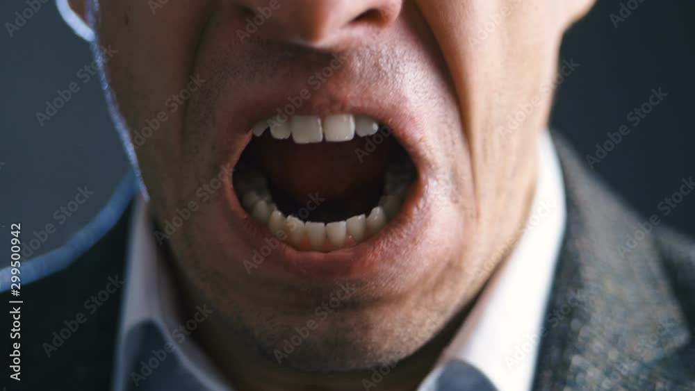 Close-up mouth of angry annoyed boss man screaming at camera. Businessman aggressively shouts experiencing stress at work.