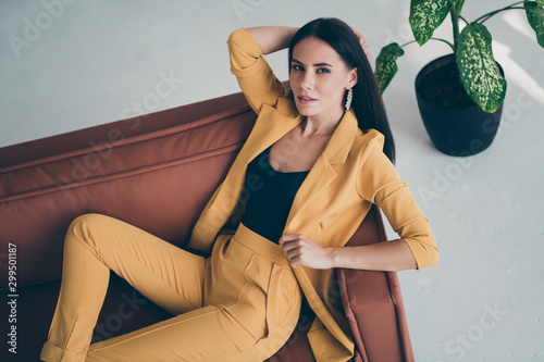Top above high angle photo of elegant sweet fancy girl lady lie on brown leather couch want attract handsome millionaire man wearing stylish good looking clothes indoors