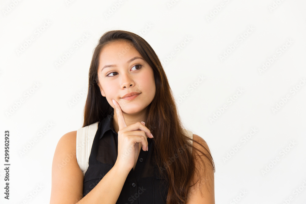 Pensive student girl touching face with finger. Young Latin woman in casual standing isolated over white background, looking at copy space away. Advertising concept Pensive student girl touching face with finger. Young Latin woman in casual standing isolated over white background, looking at copy space away. Advertising concept