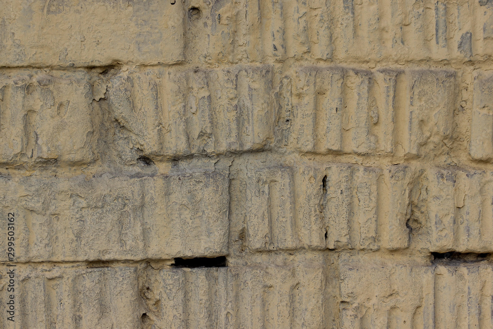 Texture of an old brick wall coated with yellow paint Texture of an old brick wall coated with yellow paint