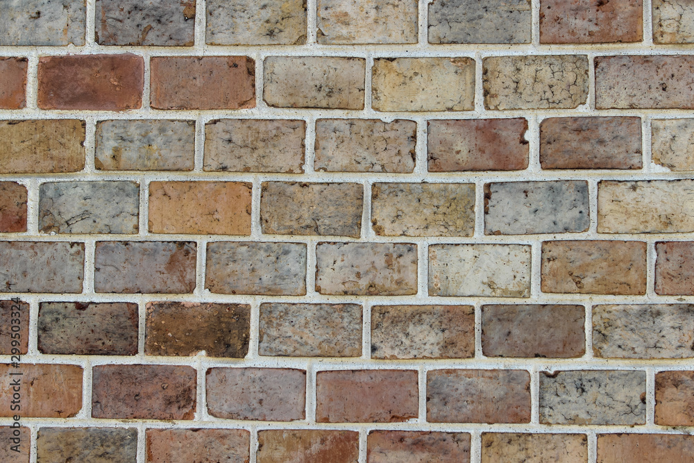 Texture of an old damaged decorative brick wall made of bricks of different colors Texture of an old damaged decorative brick wall made of bricks of different colors
