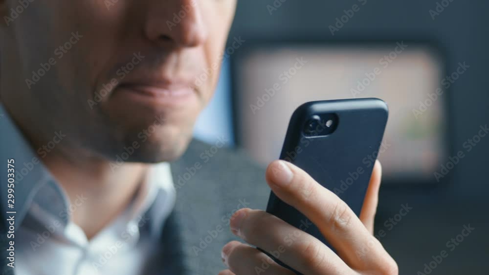 Aggressive businessman talking on a video call on a mobile phone. The man screams furiously and shows aggression to the interlocutor. Office background. Stress at work.
