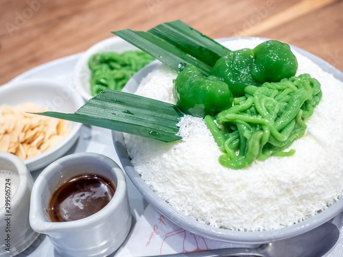 Lod chond, Thai style noodle-like dessert made from flour and pandan, create as ice shaving with coconut milk in dessert shop photo