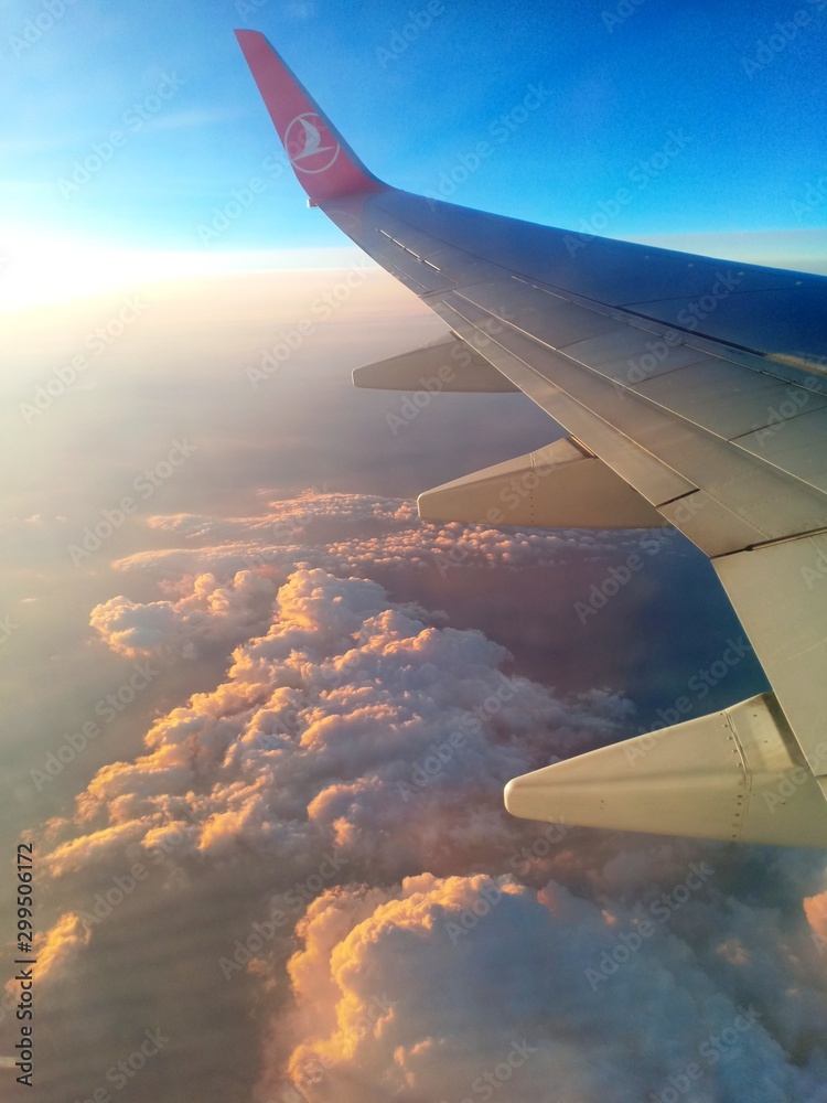 Obraz premium wing of an airplane flying above the clouds