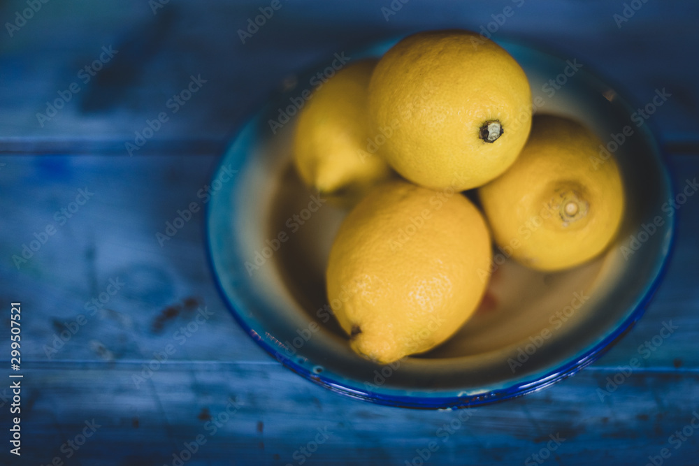 Heap of 4 lemons on blue background