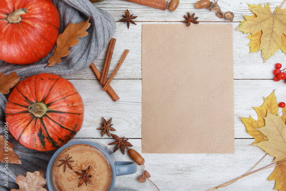 Grey spicy coffee cup, plaid or scarf, yellow leaves, pumpkins, blank paper on white wooden table. Autumn drink concept. Fall, spicy latte, thanksgiving, top, copy space Grey spicy coffee cup, plaid or scarf, yellow leaves, pumpkins, blank paper on white wooden table. Autumn drink concept. Fall, spicy latte, thanksgiving, top, copy space
