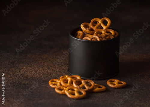 small salty pretzels in a black bowl on dark background