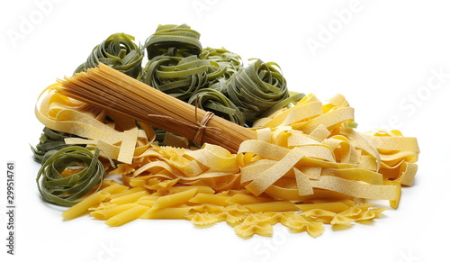 Raw pasta pile with pappardelle, tagliatelle, penne rigate, farfalle and integral spaghetti isolated on white background photo