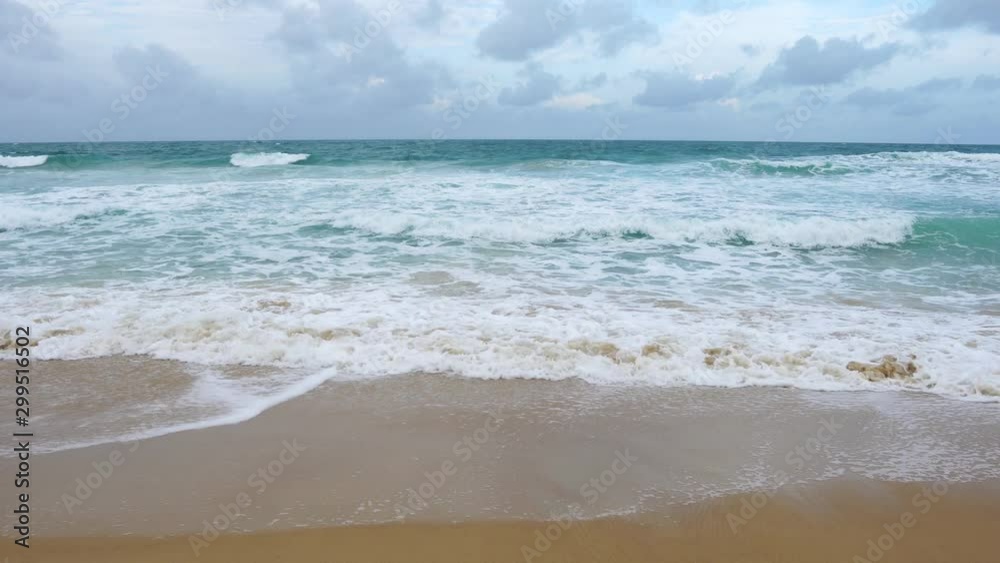 Beautiful beach with wave crashing on sandy shore and clear blue sky over sea in summer travel season Beautiful beach with wave crashing on sandy shore and clear blue sky over sea in summer travel season