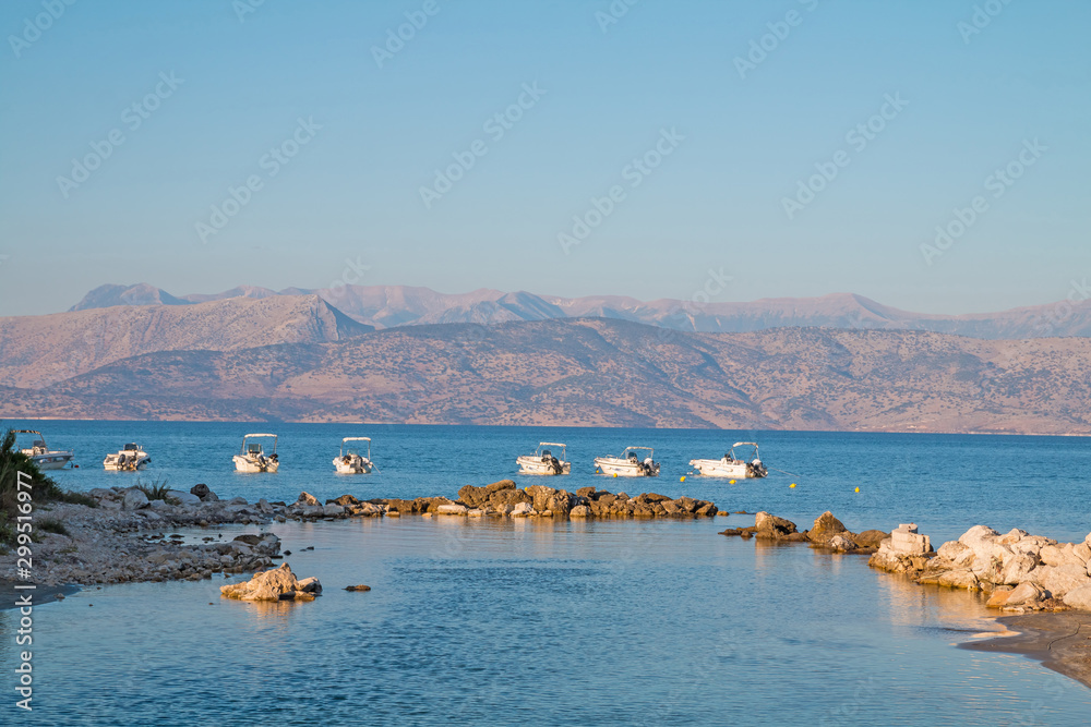 Panoramic view at hills of Albania. View from Corfu Island in Greece. Motor boats in background