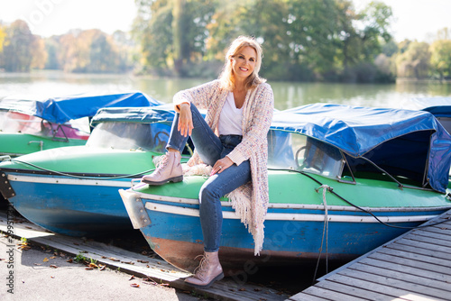 Attraktive Frau im mittleren Alter sitzt auf einem Boot photo