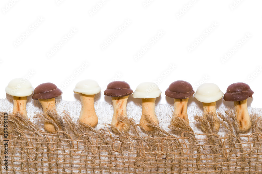 Sweet cookies for children in the shape of mushrooms with chocolate on the fabric rustic style, copy space, festive background for Christmas