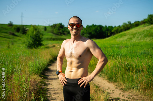 Man without t-shirt looking in camera and smiling