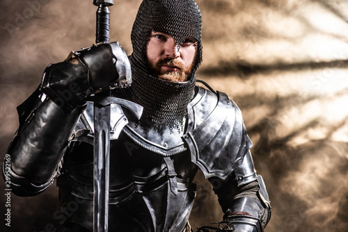 Wallpaper Mural handsome knight in armor holding sword on black background