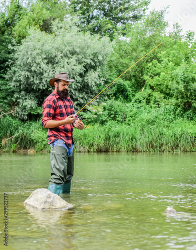 Man bearded fisherman. Fisherman fishing equipment. River lake lagoon pond. Trout farm. Fisherman alone stand in river water. Hobby sport activity. Fish farming pisciculture raising fish commercially