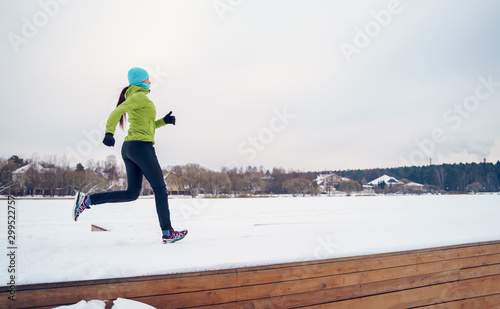 Photo of young athlete girl running in winter park