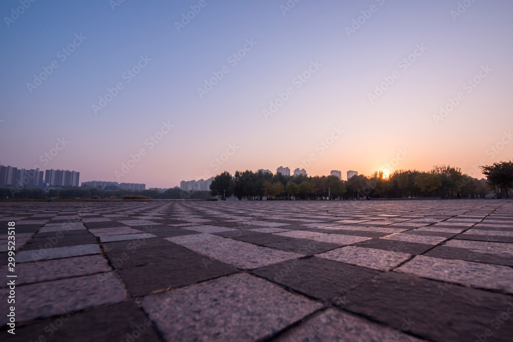 Empty city square marble pavement and beautiful blue sky in the background at sunrise