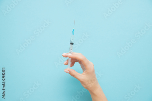 Foto Beauty spa doctor holding syringe on blue background