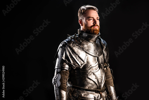 handsome knight in armor looking away isolated on black