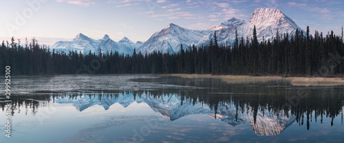 Almost nearly perfect reflection of the Rocky mountains in the Bow River. Near Canmore, Alberta Canada. Winter season is coming. Bear country. Beautiful landscape background concept. © Michal