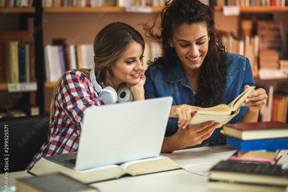 Two female students study in the college library.Learning and preparing for exam. Two female students study in the college library.Learning and preparing for exam.