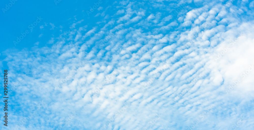 Fluffy bright white clouds look like sea wave with a beautiful clear blue sky ozone and background sunshine in the summer morning. Fluffy bright white clouds look like sea wave with a beautiful clear blue sky ozone and background sunshine in the summer morning.