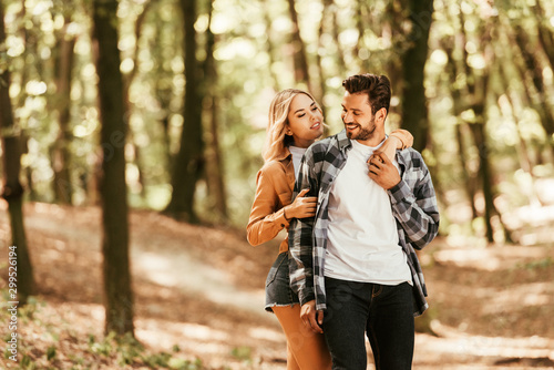 attractive girl embracing happy boyfriend while walking in park © LIGHTFIELD STUDIOS