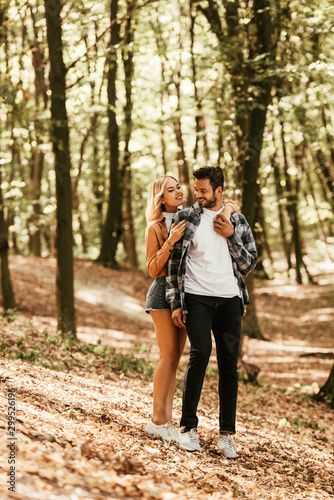 happy girl embracing handsome boyfriend while walking in park © LIGHTFIELD STUDIOS