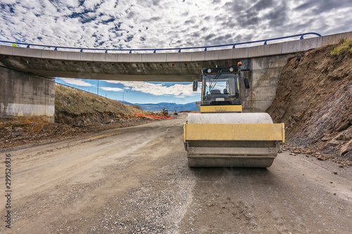 Steamroller performing leveling work on a road under construction