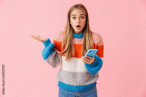 Confused young girl wearing sweater holding mobile phone