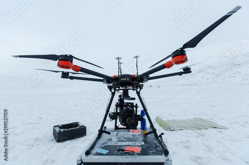 Professional video camera and modern drone in winter cold field.