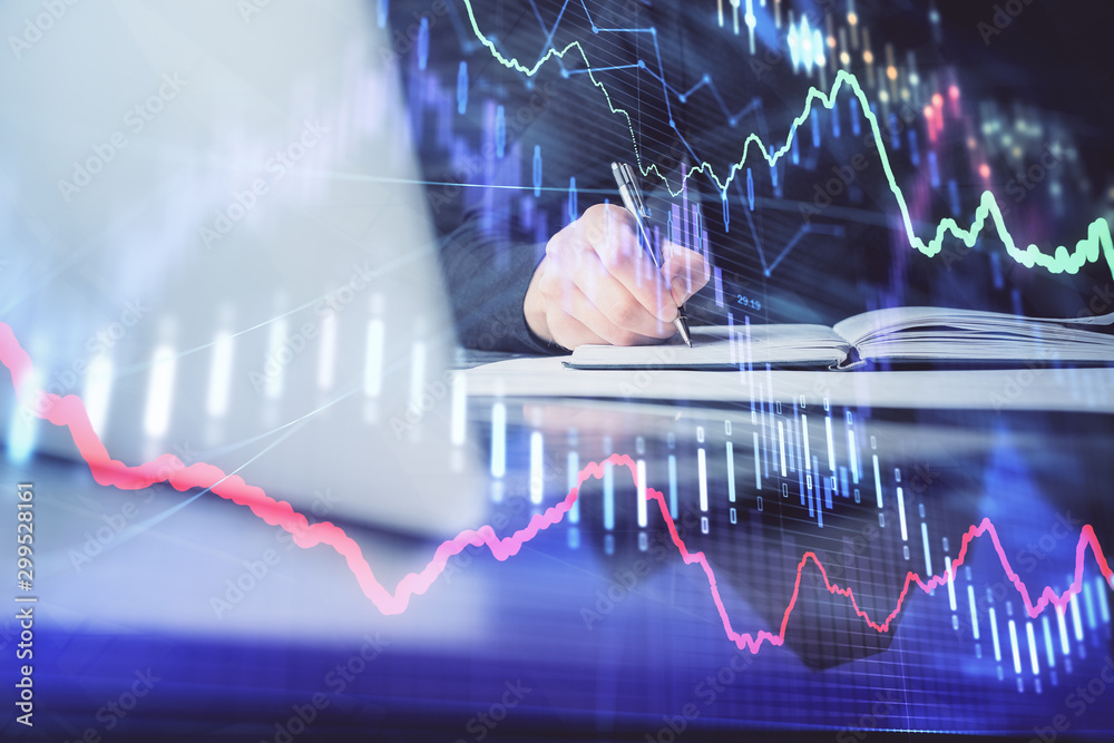 Double exposure of businessman with laptop and stock market forex chart.