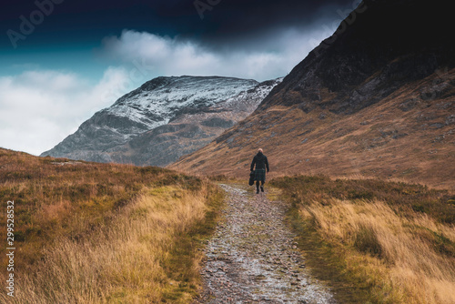 scotsman in kilt walks the path through Glencoe, lochaber, highlands, scotland, uk. photo