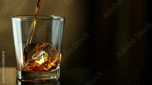 Super slow motion of pouring whiskey into glass, speed ramping effect. Filmed on high speed cinema camera, 1000fps photo