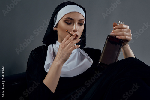 Принти на полотні Cropped shot of a nun, sitting on a black chair