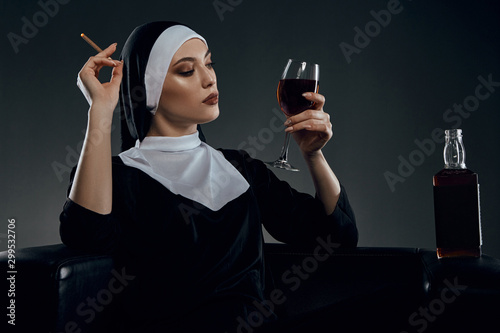 Принти на полотні Cropped half-turn shot of a nun, sitting on a chair
