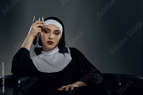 фотографія Cropped shot of a nun, sitting on a chair