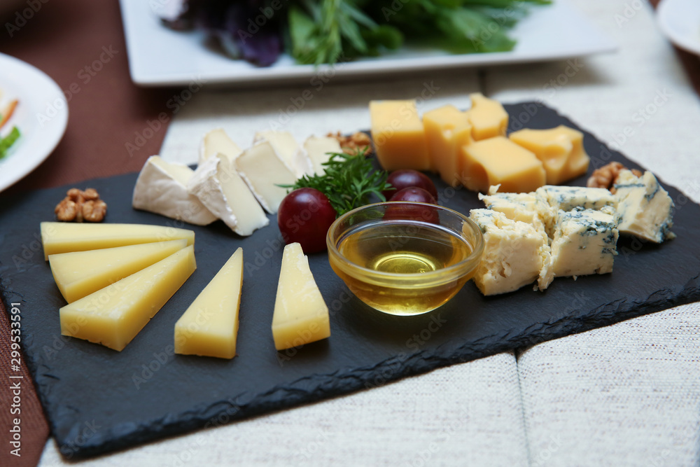 cheese set on the table. dish with different cheeses on a black rug. cheese composition in a restaurant. cheese set on the table. dish with different cheeses on a black rug. cheese composition in a restaurant.