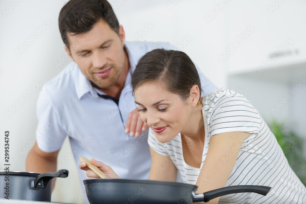 portrait of a cheerful young couple cooking together portrait of a cheerful young couple cooking together
