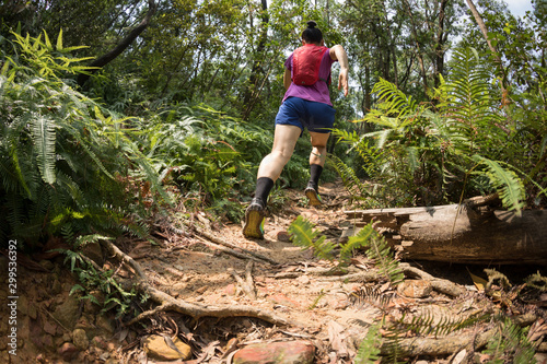Photography Woman trail runner running in tropical forest