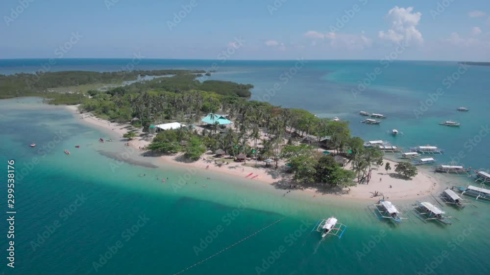 Exotic Cowrie Island with crystal clear waters at Honda Bay in Palawan, aerial shot in Philippines Exotic Cowrie Island with crystal clear waters at Honda Bay in Palawan, aerial shot in Philippines