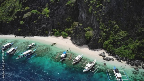 Tropical white beach in El Nido with boats and tourists, drone shot at Talisay Beach, Palawan, Philippines photo