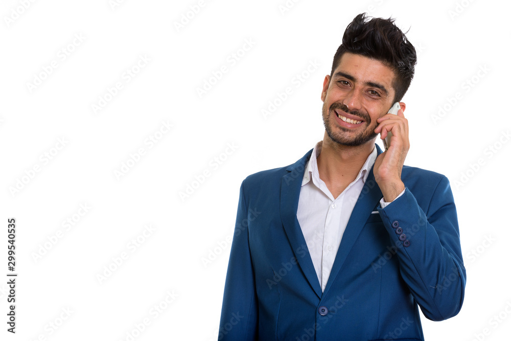 Young handsome bearded Persian businessman in suit using phone Young handsome bearded Persian businessman in suit using phone