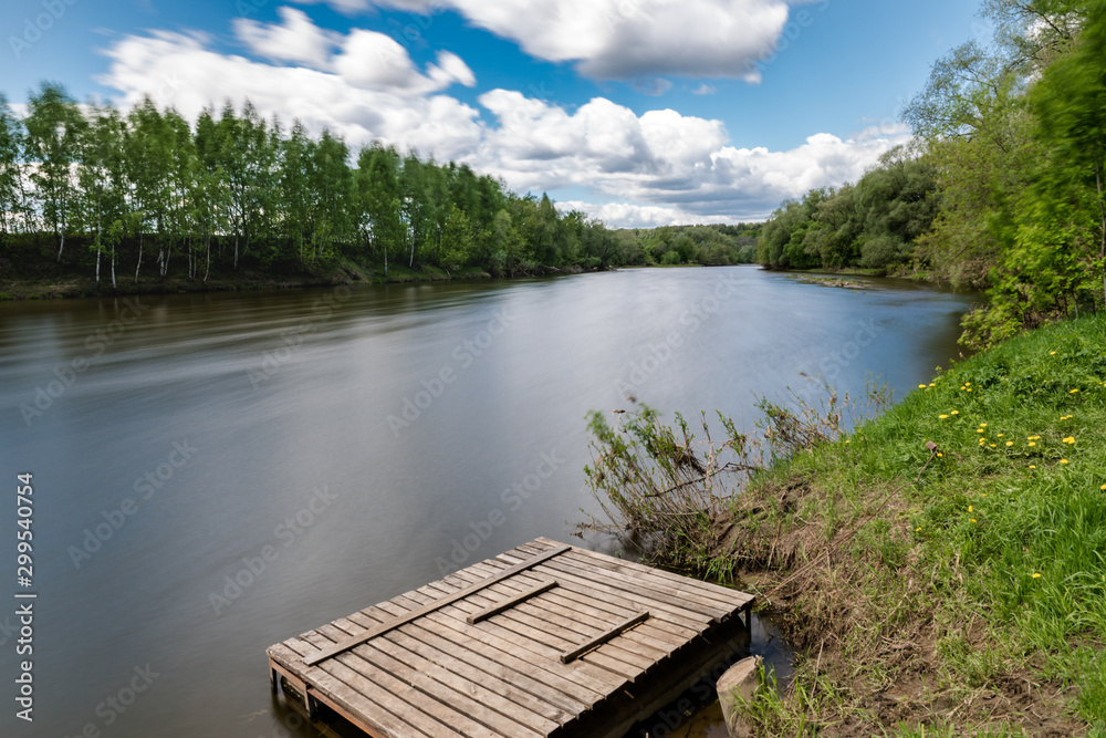 Naklejka premium summer riverscape with blue sky, clouds and water reflections