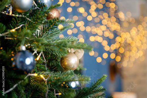 Modern design Christmas tree decorated with balls and garlands - navy blue, brown, beige. Winter holidays composition.